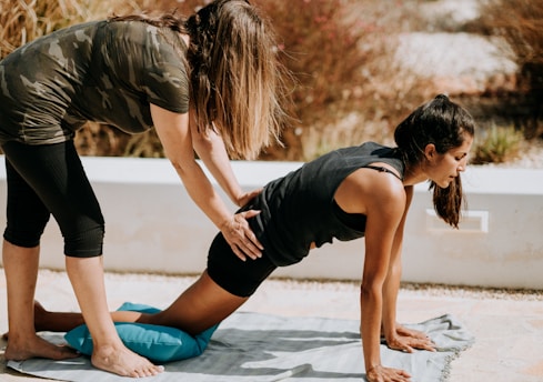 woman in black tank top and black shorts kneeling on mat