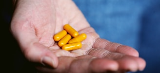 yellow medication pill on persons hand