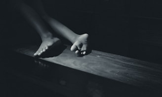 a black and white photo of a person's feet on a table