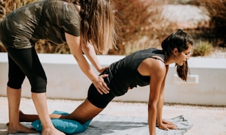 woman in black tank top and black shorts kneeling on mat