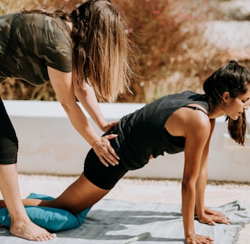 woman in black tank top and black shorts kneeling on mat