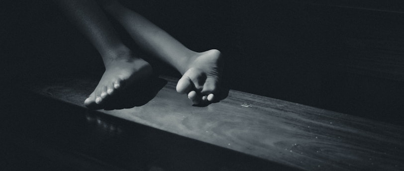 a black and white photo of a person's feet on a table