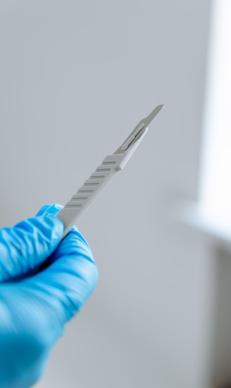 a person in blue gloves holding a toothbrush
